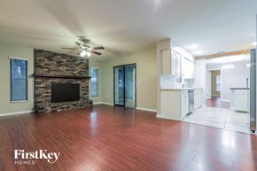 Sarasota house for rent - an empty living room with a fireplace and wooden floors