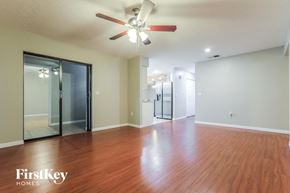 Sarasota house for rent - an empty living room with wood flooring and a ceiling fan