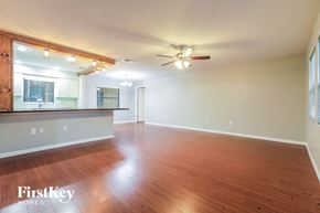 Sarasota house for rent - an empty living room with wood floors and a ceiling fan