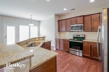 Summerville house for rent - a kitchen with wooden cabinets and granite counter tops and stainless steel appliances
