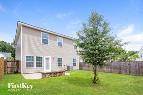 Summerville house for rent - a backyard with a house and a tree in the grass