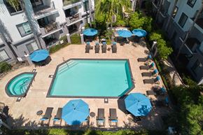 San Diego apartment for rent - a swimming pool with umbrellas and chairs around it in front of a building