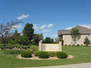Appleton apartment for rent - a sign in front of a building with a lawn and trees