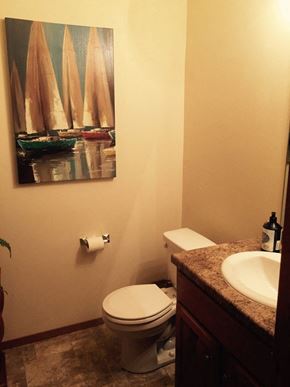 Green Bay apartment for rent - a bathroom with a toilet and a painting of sail boats