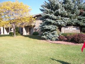 Green Bay apartment for rent - a lawn in front of a building with a sign