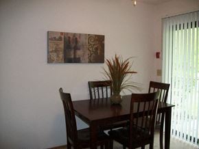 West Bend apartment for rent - a dining room table with chairs and a painting on the wall