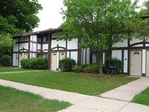 West Bend apartment for rent - a building with a lawn and trees in front of it