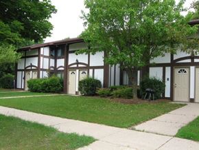West Bend apartment for rent - a building with a lawn and trees in front of it