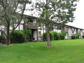 West Bend apartment for rent - a view of the exterior of an apartment building with grass and trees