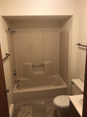 West Bend apartment for rent - A white toilet sits in a bathroom next to a walk-in shower.