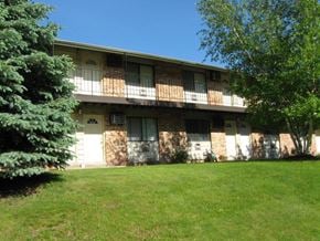 St. Francis apartment for rent - an apartment building with a green lawn and trees