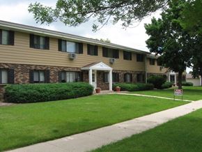West Bend apartment for rent - a building with a lawn and a sidewalk in front of it