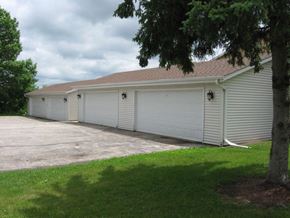 West Bend apartment for rent - a white garage with a driveway next to a tree