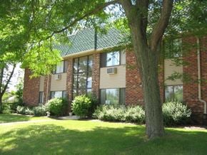 Menomonee Falls apartment for rent - a large brick building with a tree in front of it