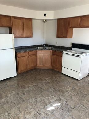 Menomonee Falls apartment for rent - an empty kitchen with white appliances and wooden cabinets