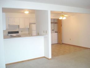 Watertown apartment for rent - an empty living room with a kitchen and a ceiling fan
