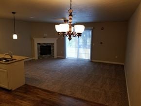 Sheboygan apartment for rent - an empty living room with a fireplace and a chandelier