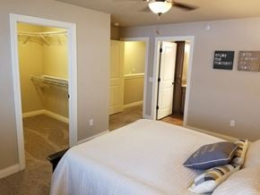 Sheboygan apartment for rent - a bedroom with a bed and a closet and a ceiling fan