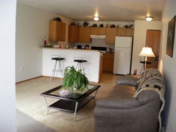Sheboygan Falls apartment for rent - an open kitchen and living room with a couch and a table