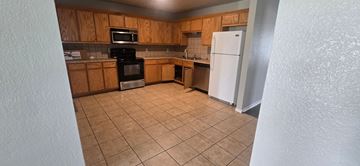 Copperas Cove apartment for rent - A kitchen with a white refrigerator and wooden cabinets.