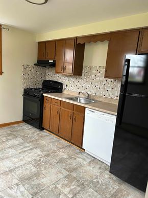 Hamburg apartment for rent - A kitchen with black appliances and wooden cabinets.
