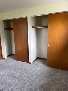 Hamburg apartment for rent - Three brown closet doors in a white room.