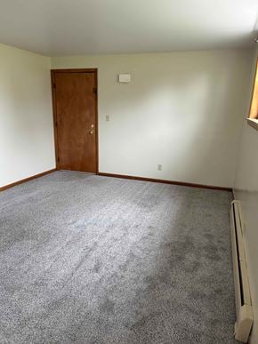 Hamburg apartment for rent - A room with a carpeted floor, a door, and a window with blinds.
