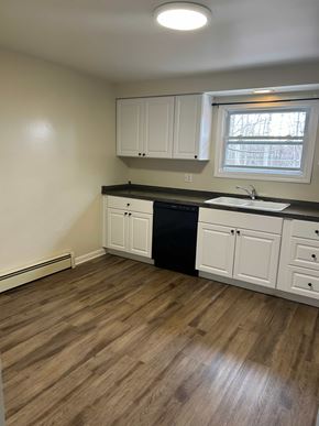 Hamburg apartment for rent - A kitchen with white cabinets and a black dishwasher.