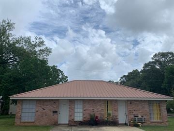 Hammond apartment for rent - an old brick house with a cloudy sky in the background