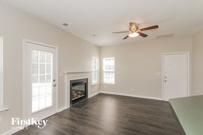 Charlotte house for rent - A spacious room with a fireplace and a ceiling fan.