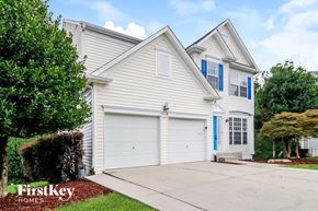 Jamestown house for rent - A two-story house with a white garage door and blue shutters.