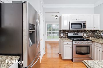 Jamestown house for rent - A kitchen with a stainless steel refrigerator and white cabinets.