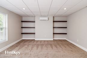 Jamestown house for rent - A spacious room with a carpeted floor and a window on the left side.