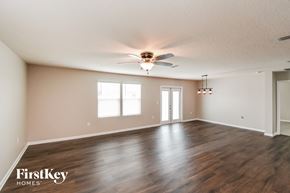 Jacksonville house for rent - A spacious room with wooden floors and a ceiling fan.