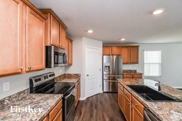 Jacksonville house for rent - A kitchen with wooden cabinets and granite countertops.