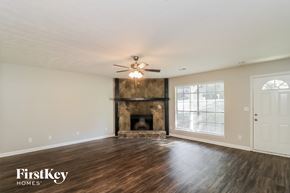 Marietta house for rent - an empty living room with a fireplace and a ceiling fan