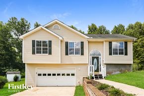 Flowery Branch house for rent - a tan house with a white garage door