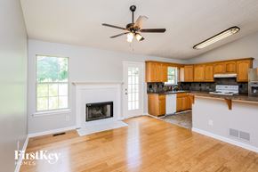 Flowery Branch house for rent - an empty living room with a ceiling fan and a fireplace