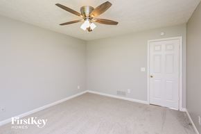 Flowery Branch house for rent - a bedroom with a ceiling fan and a white door