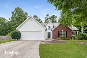 Flowery Branch house for rent - a white and red brick house with white siding and a driveway