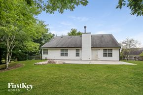 Flowery Branch house for rent - a white house with a grassy yard and a wood fence