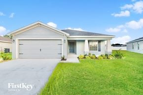 Zephyrhills house for rent - a white house with a lawn and a garage door