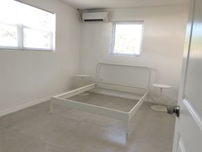 South Miami apartment for rent - an empty room with a crib in the corner and two windows
