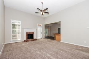 Concord house for rent - an empty living room with a fireplace and a ceiling fan