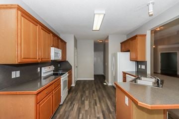 Concord house for rent - an empty kitchen with wooden cabinets and a white refrigerator