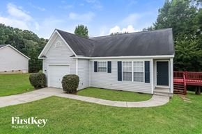 Monroe house for rent - A house with a grey roof and a white garage door is for sale.