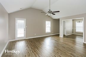Monroe house for rent - A spacious room with wooden floors and a ceiling fan.