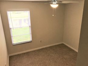 Bradenton house for rent - a bedroom with a ceiling fan and a window