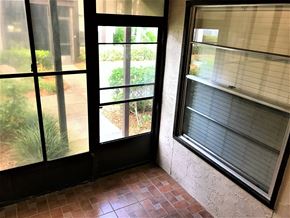 Bradenton house for rent - the living room of a house with windows and a brick floor