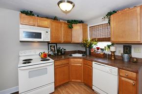 Albany townhouse for rent - a kitchen with white appliances and wooden cabinets